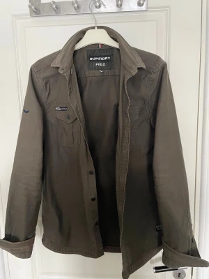 Overshirt från Superdry  - Snygg grön Overshirt från märket Superdry. Overshirt är i fint skick och i storlek M. Hör av dig om du har någon fundering!