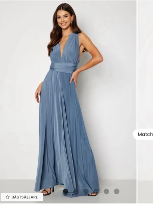 Blå långklänning - Elegant blå långklänning, som knyts till en disigt man själv gillar. Klänningen är ärmlös och har ett mjukt, fallande tyg som ger en lyxig känsla. Perfekt för speciella tillfällen. Köpt på bubbleroom, Multi Tie maxi dress. Klippt till att vara lagom för 165+ låga klackar
