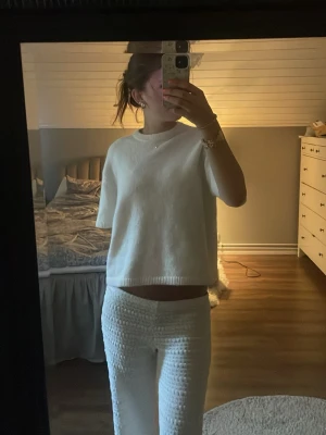 Vit stickad T-shirt GinaTricot - Vit stickad tröja med avslappnad passform, korta ärmar och rund hals. Tröjan har ribbade kanter och är gjord i ett mjukt material. Storlek M och från Ginatricot. Använd ca två gånger så i toppen-skick. 🩷