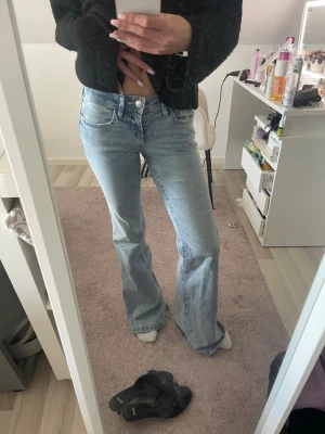 Ljusblå bootcut jeans - Säljer ett par ljusblå bootcut jeans med klassisk femficksmodell och låg midja. Storlek xs tall.