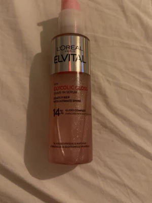 L'Oréal Elvital Glycolic Gloss Serum - L'Oréal Elvital Glycolic Gloss Leave-In Serum är ett glansgivande serum för håret med 14% gloss complex och glykolsyra. Kommer i en rosa skimrande plastflaska med pump och silverdetaljer. Perfekt för att boosta glans och mjukhet i håret.