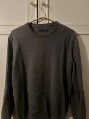 Grön stickad tröja från Berkeley - Grön stickad tröja från Berkeley med rund halsringning och långa ärmar. Tröjan har en enkel och stilren design, perfekt för lager på lager och passar till det mesta. Materialet ser ut att vara mjukt och bekvämt.
