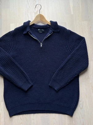 ASOS Design stickad half-zip tröja - blå L - Denna blå half-ziptröja från ASOS Design är använd, men i bra skick utan slitage. Tröjan är dock något nopprig på grund av materialet. Half zip-tröjan har en tjock ribbad struktur och en normal-avslappnad passform.