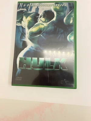 HULK 2-disc specialutgåva DVD - Säljer en 2-disc specialutgåva av filmen HULK på DVD. Omslaget är grönt med en stor bild av Hulken på framsidan. Inuti fodralet finns två skivor med tryckta motiv från filmen. Perfekt för Marvel-fans och samlare.