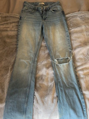 Ljusblå slitna bootcut jeans - Säljer ett par ljusblå bootcut jeans