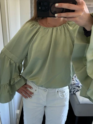 Grön blus - Grön blus med volanger. Aldrig använd, prislapp finns kvar