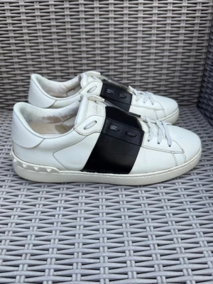 Valentino vita sneakers med svart detalj - Valentino Open || Storlek 42 || Skorna är i okej skick , däremot förekommer slitage på insida häl || Tveka inte på att höra av dig vid frågor eller funderingar 