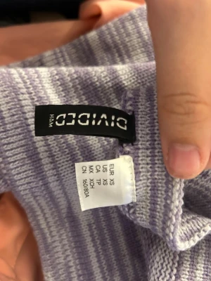 Ljuslila randig halterneckklänning XS - Superfin kort halterneckklänning från H&M Divided i ljuslila och vit randigt mönster. Klänningen är tight och ärmlös med en smickrande passform, perfekt för varma dagar. Mjuk och stretchig bomullsblandning som sitter bekvämt.