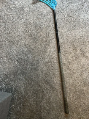 Unihoc evolabe Innebandyklubba med blått blad - Säljer en innebandyklubba med svart skaft och grått grepp. Bladet är i en klarblå färg och har ett klassiskt nätmönster. Perfekt för dig som gillar innebandy och vill ha en snygg och funktionell klubba.