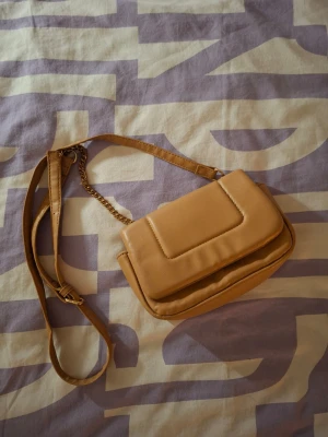 Brun handväska - Brun axel/handväska från primark. Knappt använd och är i mycket fint skick! Hör av dig vid funderingar och köp gärna en bundle för att spara på frakten! 