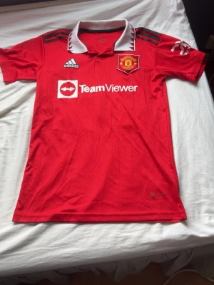 Manchester United matchtröja Adidas - Röd Manchester United matchtröja från Adidas med vit krage och svarta detaljer på axlarna. 