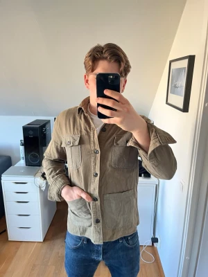 Olivgrön overshirt med fickor - Säljer en olivgrön overshirt ifrån Resteröds i bomull med fyra stora fickor framtill och knäppning hela vägen.  En extra knapp följer med. Hör gärna av dig vid frågor!