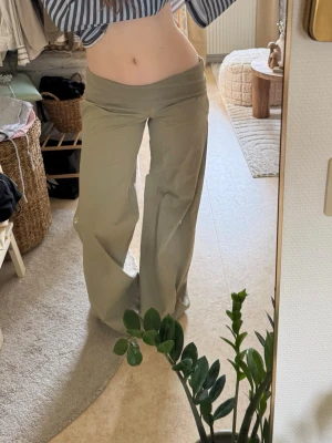 Gröna vida byxor med ribbad midja - Säljer ett par ljusgröna byxor med bred, ribbad midja och vida ben. Aldrig använda och prislapp kvar