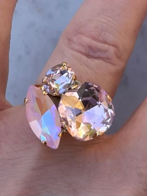 Mixed sized ring Rosa nyanser  - Mixed sized ring i guldpläterad mässing med Square 12x12mm, oval 8mm och Navette 15mm. Färg Rosaline, Rosaline De Lite och Light Rose. Ställbar storlek. Sista bilderna visar olika färgkombinationer och modeller.  Jag skickar endast spårbart, samfraktar. Fast pris. Besök gärna mina övriga annonser.  Till mina smycken använder jag kristaller från Preciosa, Aurora och Swarowski.