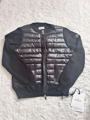 Moncler jacka cardigan  - Nyskick till moncler jacka/cardigan, jacka till dam. I storlek 2, passar dig som har XS/S. QR kod och NFC Scan funkar som den ska. Skickar med dust bag som jackan kan förvaras i. 