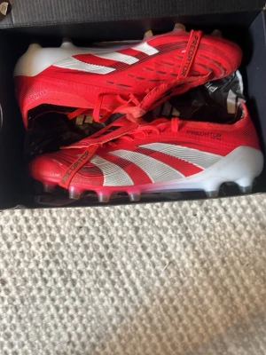 Adidas Predator Elite FT AG - Säljer mina Röda Adidas Predator då jag tyckte att det inte passade till min fot bra. De är bara använda fåtal gånger. Sko påse finns inte med då den gick sönder typ direkt, men om någon hade velat ha den endå så kan jag skicka med den.