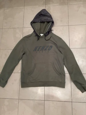Grön Kenzo hoodie med tryck - Snygg grön hoodie från Kenzo som är använd ett fåtal gånger. Perfekt för dig som gillar och vill ha något bekvämt och stilrent. Kontakta för mer!!