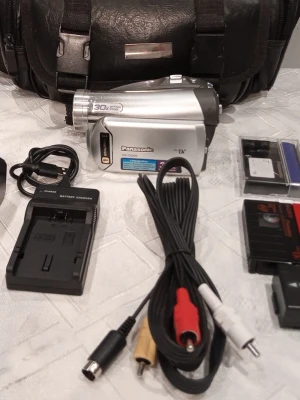 Panasonic NV-GS60 MiniDV videokamera silver - Säljer en silverfärgad Panasonic NV-GS60 videokamera med 30x optisk zoom och MiniDV-format. Medföljer laddare, batteriladdare, AV, dv band . Kameran har kompakt design och tydliga knappar, perfekt för att filma minnen eller digitalisera dina inspelade  video. Ring vid frågor på 0700441696,   Kameran kan skickas, hämtas i Trollhättan eller i Göteborg