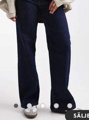 Mörkblå wide leg jeans - Säljer ett par mörkblå jeans med wide leg passform och hög midja. Jeansen har klassisk femficksdesign och raka, vida ben som ger en avslappnad och trendig look. Perfekta för dig som gillar en loose fit och vill ha ett par stilrena basjeans.