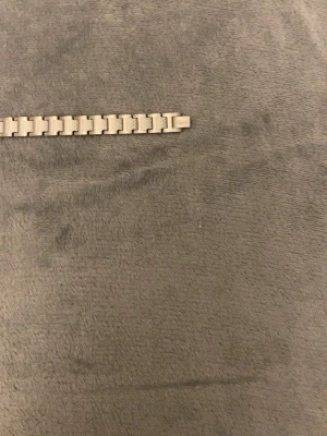 Silverfärgat länkarmband i metall Lacoste - Stilrent armband i silverfärgad metall med klassisk länkdesign. Perfekt för dig som gillar en clean och modern look. Armbandet har rektangulära länkar som ger en robust känsla och passar till många olika stilar. Utan box!