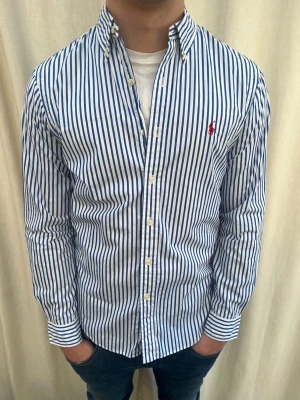 Randig skjorta från Ralph Lauren - Sjukt snygg skjorta från Ralph Lauren. Mycket bra skick. Strl M, personen på bilden är 184 cm. Skicka gärna prisförslag. Kika in min profil för mer schyssta plagg