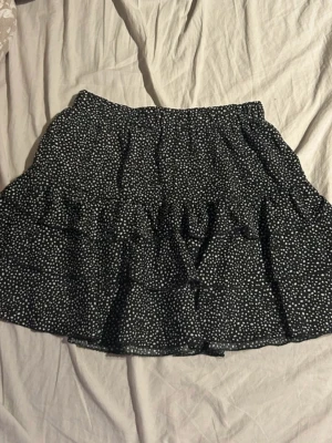 Svart kjol med vita prickar  - Säljer en svart tight kortkjol med rynkade detaljer framtill. Enkel, stilren design som funkar till nästan allt i garderoben. Mjukt och stretchigt material för en bekväm passform. En riktig bas-kjol som alltid funkar.(ifrån shein) 