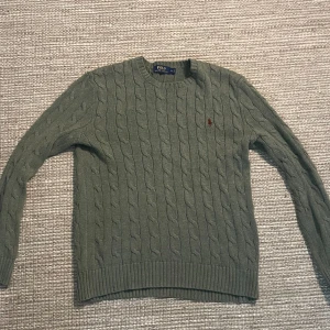 Grön Stickad Ralph Lauren Tröja  - Använt denna en gång. Passar fint med en skjorta under och passar med de flesta skor och byxor.  