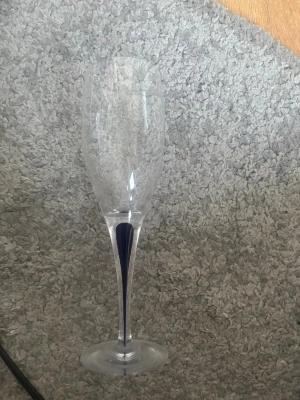 Orrefors vinglas - blå droppe  - Snyggt champagneglas i klart glas med en smal, elegant form och en blå detalj i foten. Perfekt för att höja stämningen vid speciella tillfällen. Glaset har en klassisk kupa och lång smal fot som ger en stilren look.