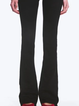 Svarta bootcut leggings - Säljer ett par svarta leggings med bootcut-modell och utsvängda ben. De är stretchiga och sitter tajt upptill men blir vidare nedtill. Perfekta att styla med sneakers eller boots för en trendig look.