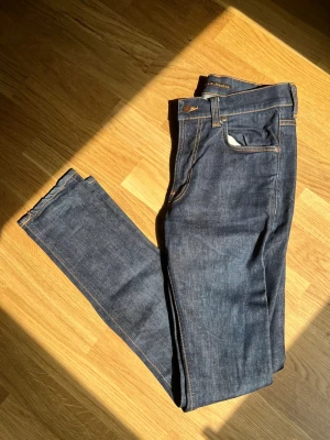 Mörkblå Nudie Jeans - Klassiska Nudie jeans till salu, Storlek Waist 30 / Waist 34. Plagget är i mycket bra skick, inga defekter. Hör av dig vid intresse/frågor. PRIS KAN DISKUTERAS!