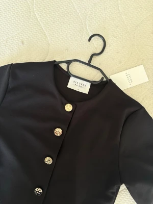 Svart topp med guldiga detaljer  - Svart topp med guldiga detaljer från Sisters Point. Prislapp kvar. Nypris 400kr