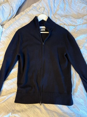 Stickad Full Zip från These Glory Days 100% Merino Ull - Säljer en väldigt snygg marinblå full zip från These Glory Days. Storlek M men tycker den sitter mer som S, 100% Merino Ull. Hör gärna av er ifall ni har frågor eller prisförslag