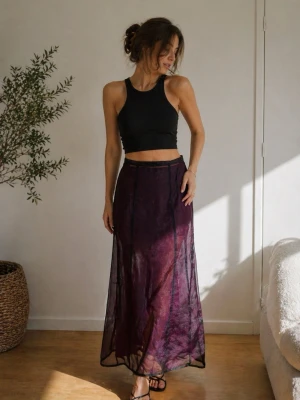 Lång transparent kjol från Studio - Snygg långkjol från Studio by Sisters i transparent svart tyg med lila underton. Kjolen har en rak passform och är perfekt för dig som vill sticka ut med en cool och trendig look. Materialet känns lätt och flowy, vilket ger en riktigt snygg siluett.