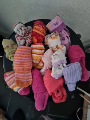 Färgglada barnstrumpor i olika mönster - Ett gäng söta och färgglada barnstrumpor i olika mönster och färger. Här finns randiga, blommiga och enfärgade strumpor i rosa, lila, orange, röd, grön och vit. Perfekta för att liva upp vardagen med mjuka material och roliga detaljer.