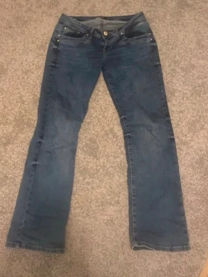 LTB jeans  - Säljer ett par klassiska blå bootcut jeans med fickor och knappstängning. Jeansen har en lätt tvättad look och är tillverkade i denim med stretch för extra komfort. Perfekta för dig som gillar en avslappnad och tidlös stil.