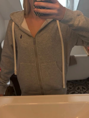 Grå hoodie från Ralph Lauren - Grå zip hoodie från RL. Storlek S. Fick den i julklapp förra året och har använt fåtal gånger. Inga defekter.