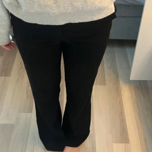 Svarta bootcut byxor - Svarta byxor  med bootcut-silhuett och klassisk dragkedja samt knapp framtill.  ”Haken” för att stänga byxorna är däremot gått sönder, så ett projekt för någon som är duktig att sy :) Annars är de i väldigt fint skick