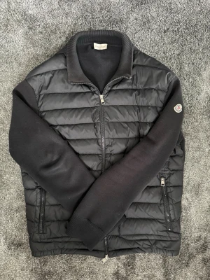 Moncler Cardigan  - Svart Moncler Cardigan i storlek L men passar även M. Bra skick utan några synliga skador, kom gärna med frågor vid funderingar eller prisförslag