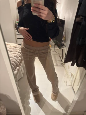 Beige mjukisbyxor med fickor - Säljer ett par beige mjukisbyxor med snörning i midjan och stora fickor bak med knappar. Byxorna är raka i modellen och har en skön, mjuk känsla. Perfekta för chill dagar och har en snygg, avslappnad look.