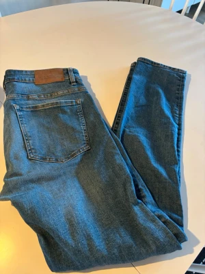 Blå slim fit jeans - Säljer ett par klassiska blå slim fit jeans, Denim. Jeansen har fem fickor och är stretchiga. Perfekta till en avslappnad stil och även snygg tvätt.