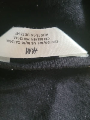 Svart långärmad topp från H&M - En enkel svart långärmad topp från H&M i storlek 164. Toppen har rund halsringning och är gjord i ett mjukt, stretchigt material som passar perfekt till jeans eller kjol. Stilren och lätt att matcha med olika outfits.