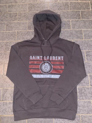 Saint Laurent hoodie  - Säljer nu min riktigt snygga gråa saint Laurent hoodie | 10/10 skick helt ny | står m men den sitter som en s | skriv vid frågor eller intresse!