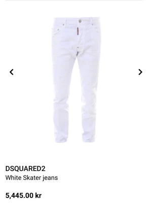 Vita skaterjeans från DSQUARED2 - Säljer ett par vita skaterjeans från DSQUARED2 med slitna detaljer och smal passform. Jeansen har klassisk femficksdesign, knappgylf och en röd logotagg vid fickan. Perfekta för dig som vill ha en trendig och edgy look.
