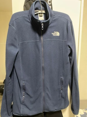 Blå fleecejacka från The North Face - Använd lite i vintern bara, köpt för 1000kr på nätet, väldigt skön och varm fleece tröja