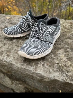 Nike SB Stefan Janoski svartvita sneakers - Unika Nike SB Stefan Janoski sneakers med svartvitt grafiskt mönster och vita sulor. Skorna har lågt skaft, snörning och är tillverkade i textilmaterial. Perfekta för dig som gillar streetwear och vill sticka ut med cool design.