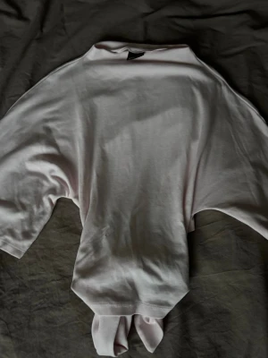 Ljusrosa topp med knyt - Jättegullig ljusrosa tröja från Gina med knytning i ryggen. Endast använd 2 gånger och säljer pga att den inte kommer till användning🤩