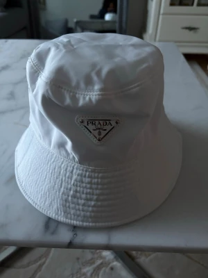 Vit Prada hatt  - Vit Prada hatt One size perfekt till sommaren aldrig använt.