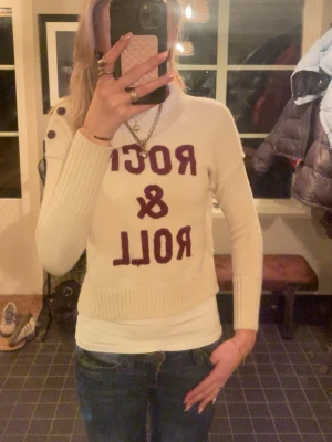 Vit Zadig Voltaire tröja - Zadig Voltaire! Vit stickad tröja med vinröd text 'ROCK & ROLL' framtill. Tröjan har en hög krage som viks ner snyggt. Avslappnad passform och trendig look. Liten i storlek!