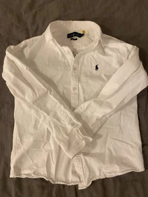 Ralph Lauren Skjorta - Vit Polo Ralph Lauren skjorta som passar storlek S. Skjortan har knappa fläckar i armhålorna men syns inte på utsidan. Skjortan är tvättad och fräsch! Seriösa bud kan godkännas.