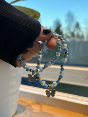 fjärilsarmband 🦋 - 39 kr/per armband 🩵 armband med pärlor i blått och vitt, dekorerade med guldiga detaljer och söta fjärilsberlocker. Perfekt för att ge en extra touch till din outfit. Tillverkade med dubbla elastiskatrådar för säkerhet!